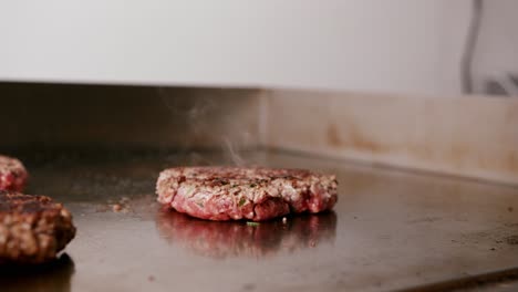 Close-up-view-of-rotating-burger-patty-in-burger-bar-kitchen