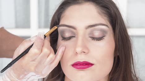 visagista de cultivos aplicando maquillaje en el modelo