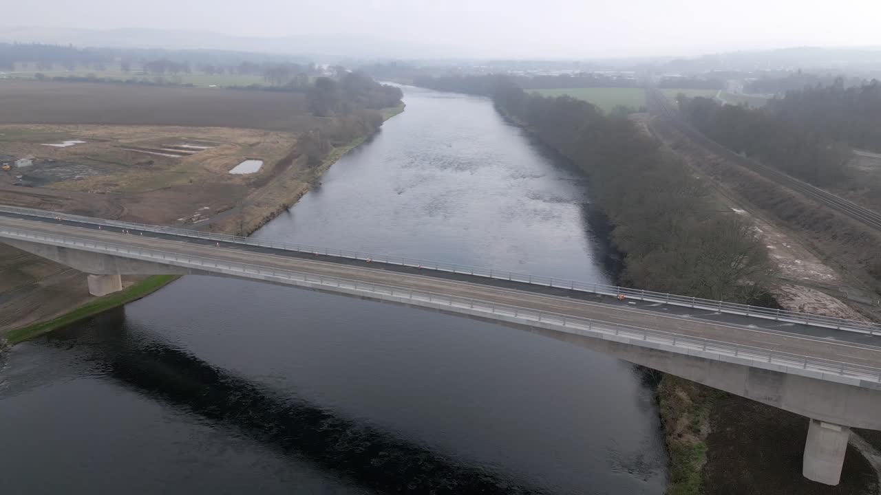Drone orbiting around the new built bridge above river Tay. Beautiful sunny spring day looking South