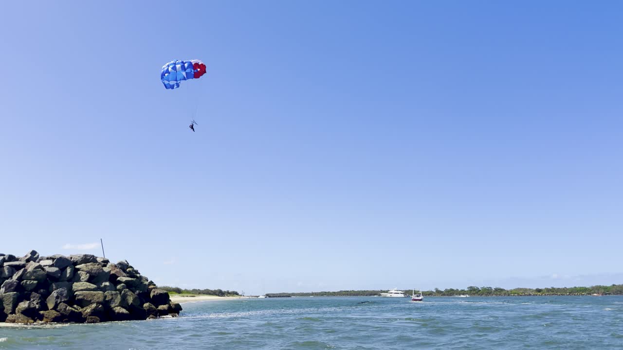 오스트레일리아 발의 낙하산으로 물 위를 는 파라세일링