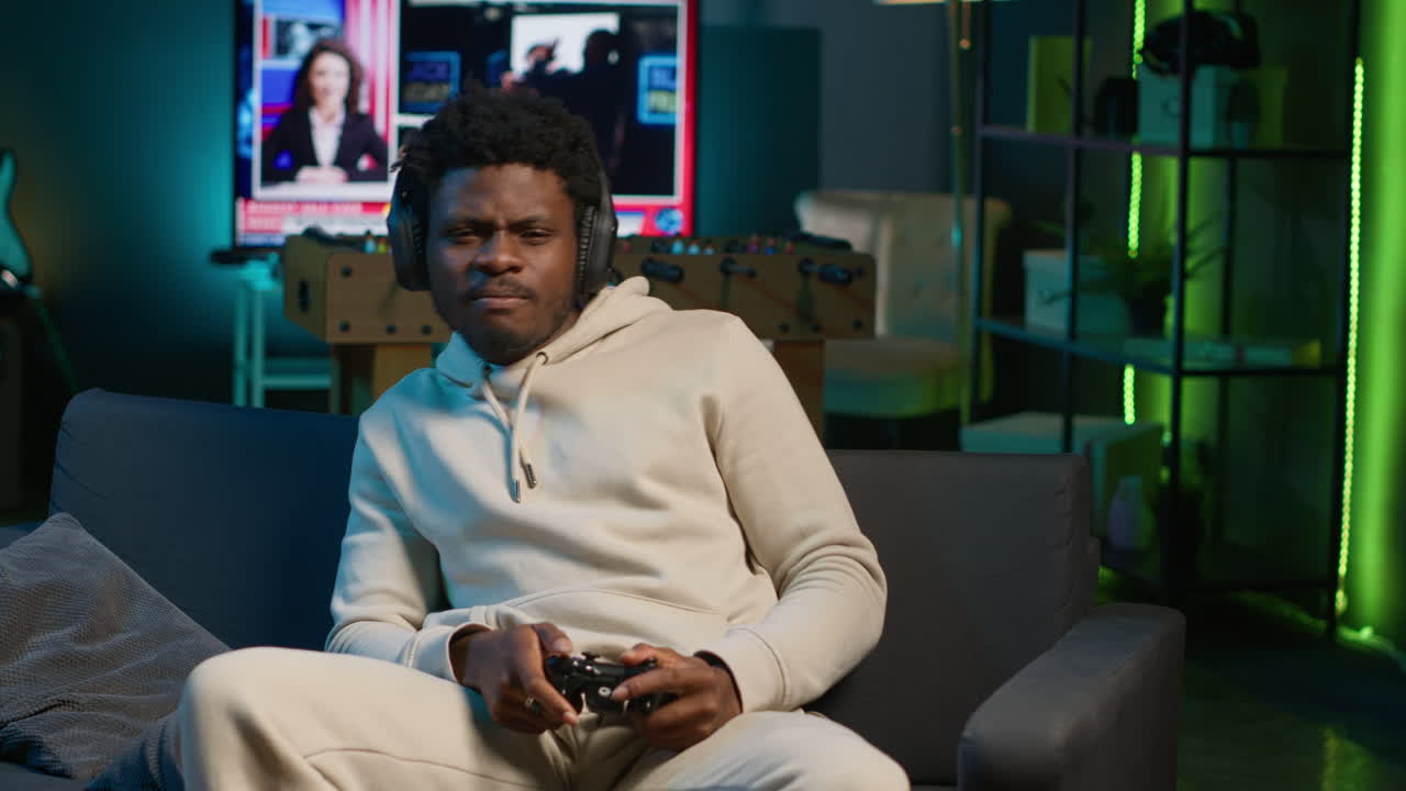 African american man plays intense online video games at home, spamming attack buttons on his controller. Gamer participating in online competition, playing on gaming console. Camera A.