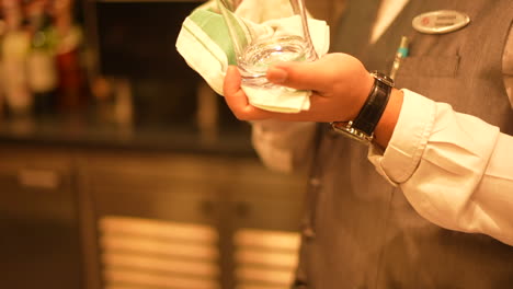 waiter cleaning a wine glass in restaurant