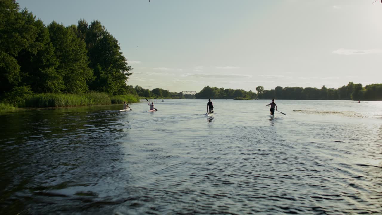 Paddleboarding og kajakroning på en flod under en bro