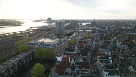 drone flies toward downtown amsterdam at sunrise in dutch capital city
