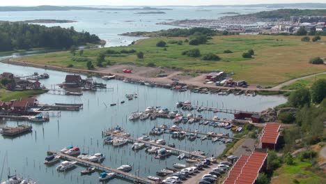 Beautiful-pier-with-many-boats-surrounded-by-green-landscape,-aerial-view