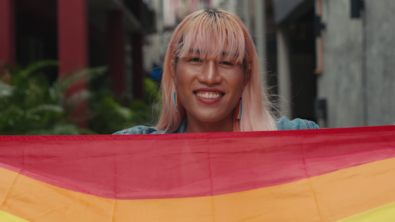 Pride parade participant holding a rainbow flag