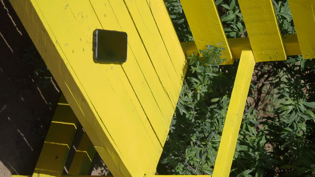 A cellphone on a yellow bench