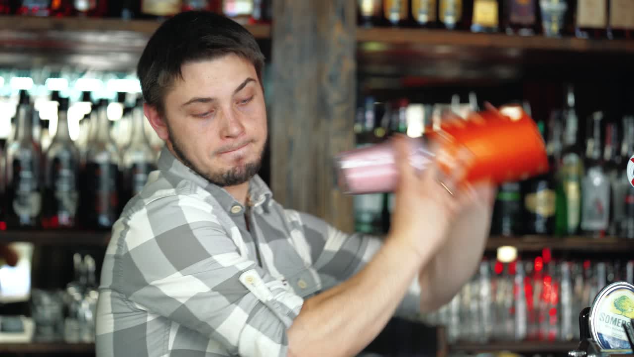 Barman al lavoro, prepara cocktail. Agita lo shaker per cocktail. Concetto di servizio e bevande.