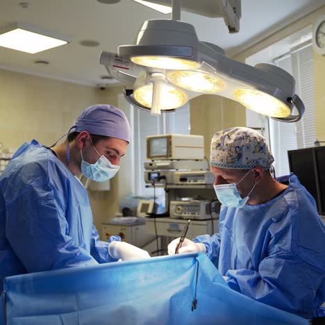 two male surgeons carrying on the operation. medical professionals performing surgery in the modern clinic. healthcare concept