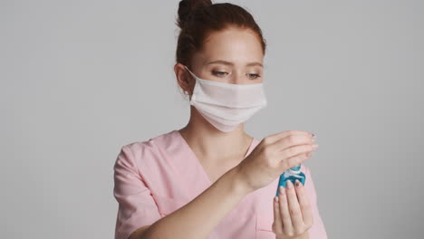 médico pelirrojo frente a la cámara sobre un fondo gris.