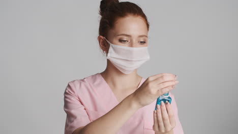 redheaded doctor in front of camera on gray background.