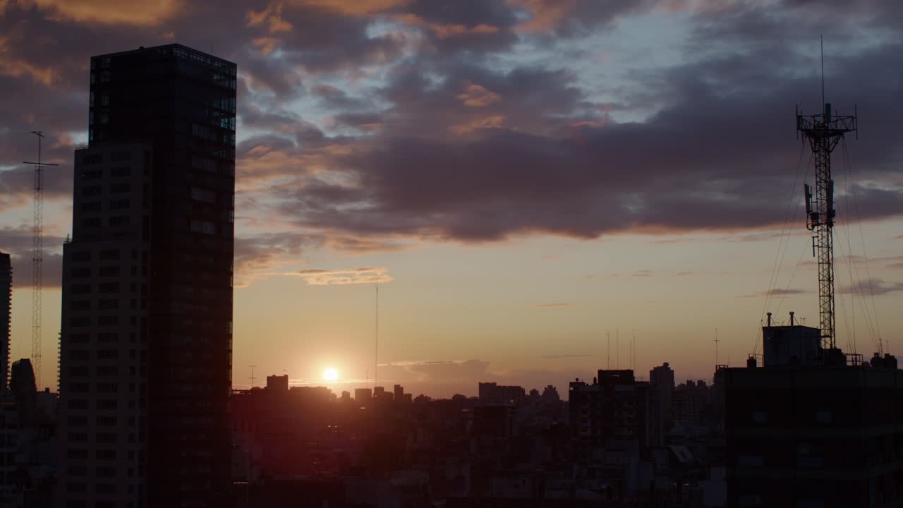 Sunrise timelapse over Buenos Aires skyline with city buildings and a tall radio tower