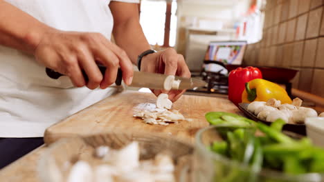 manos de chef, cuchillo y verduras en la tabla de cortar