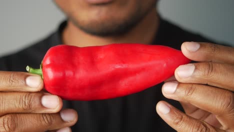man holding a red bell pepper