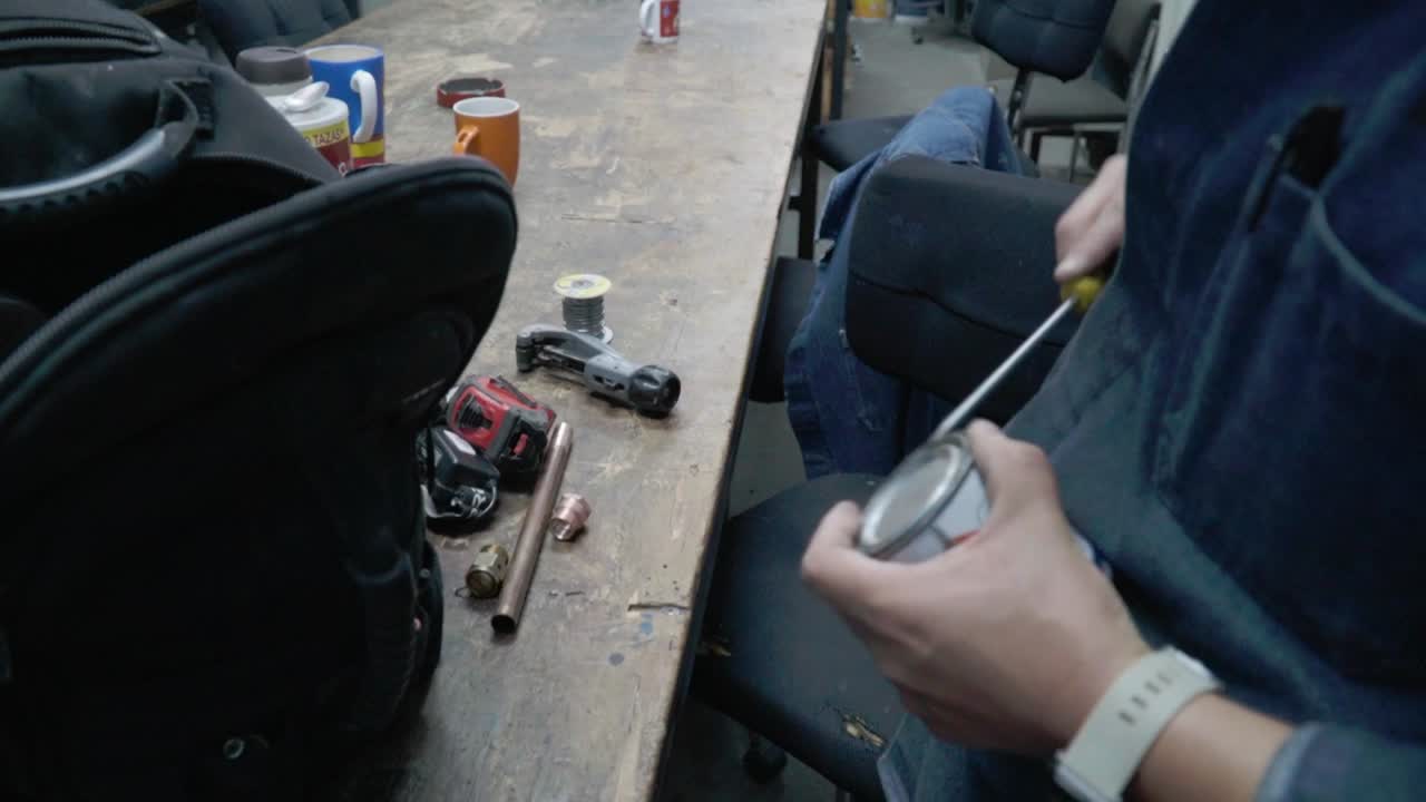 한 남자 가 회전기 로 페인트 캔 을 열고