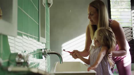 Mother-and-daughter-brushing-their-teeth-together