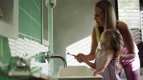 madre e hija cepillándose los dientes juntos