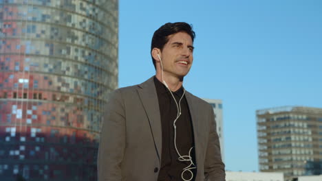 businessman listening music in earphones on street