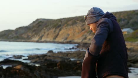 side view of mid-adult caucasian man removing clothes on the beach 4k