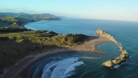 empty secluded castlepoint beach in new zealand with gentle waves, landscape aerial shot