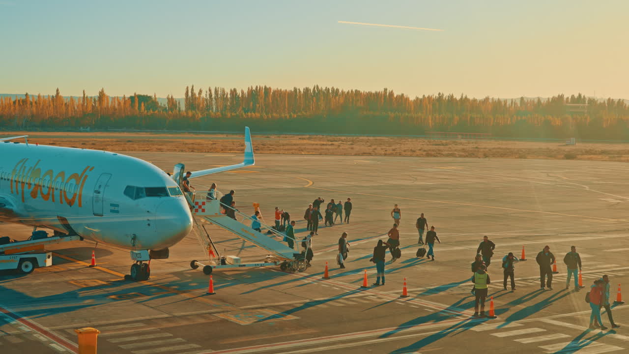 Passengers Boarding an Airplane on a Sunny Airport Tarmac
