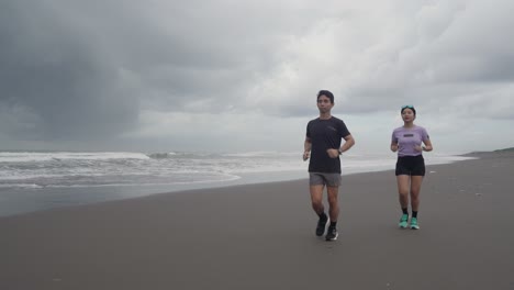 pareja corriendo en la playa