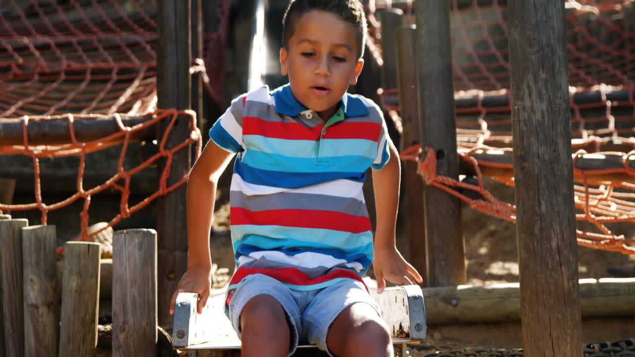 Niño deslizándose en un tobogán en el patio de recreo escolar