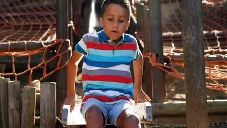 schoolboy sliding on slide in school playground