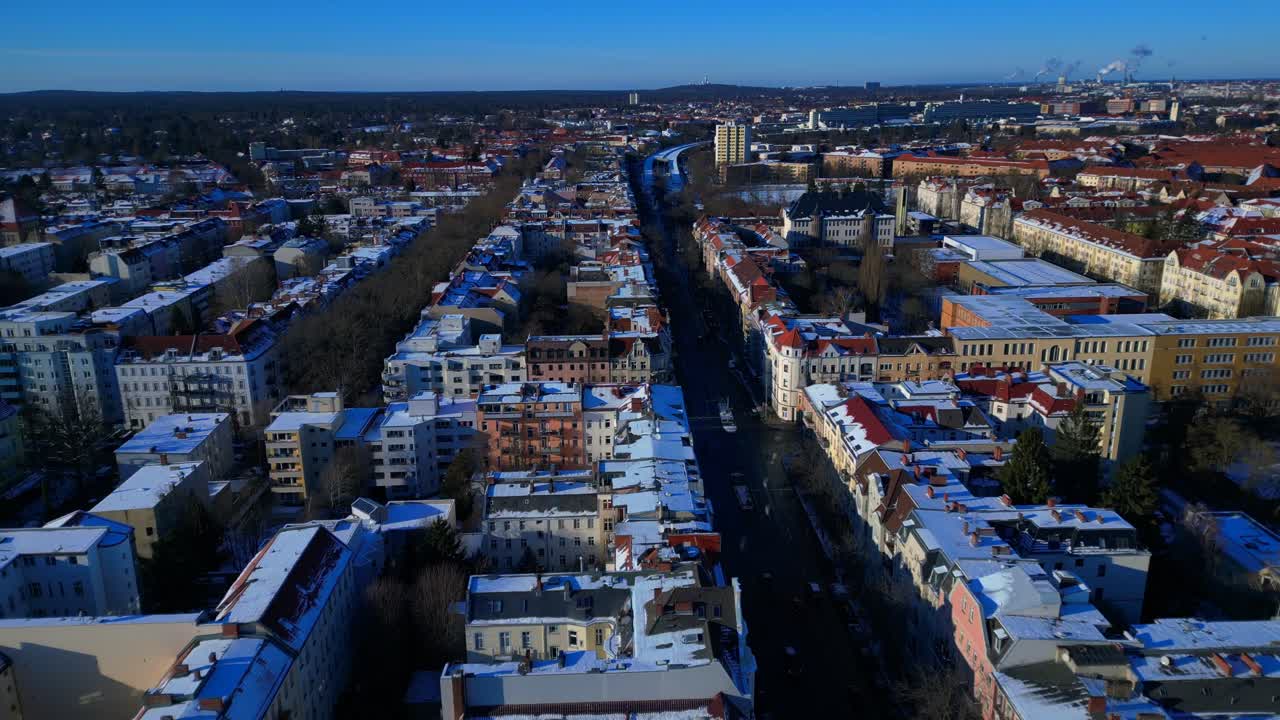 Panoramica della città di Berlino vista dall'alto, che mostra tetti innevati, edifici urbani e strade sotto un cielo azzurro luminoso. Magica veduta aerea, sorvolo con drone.