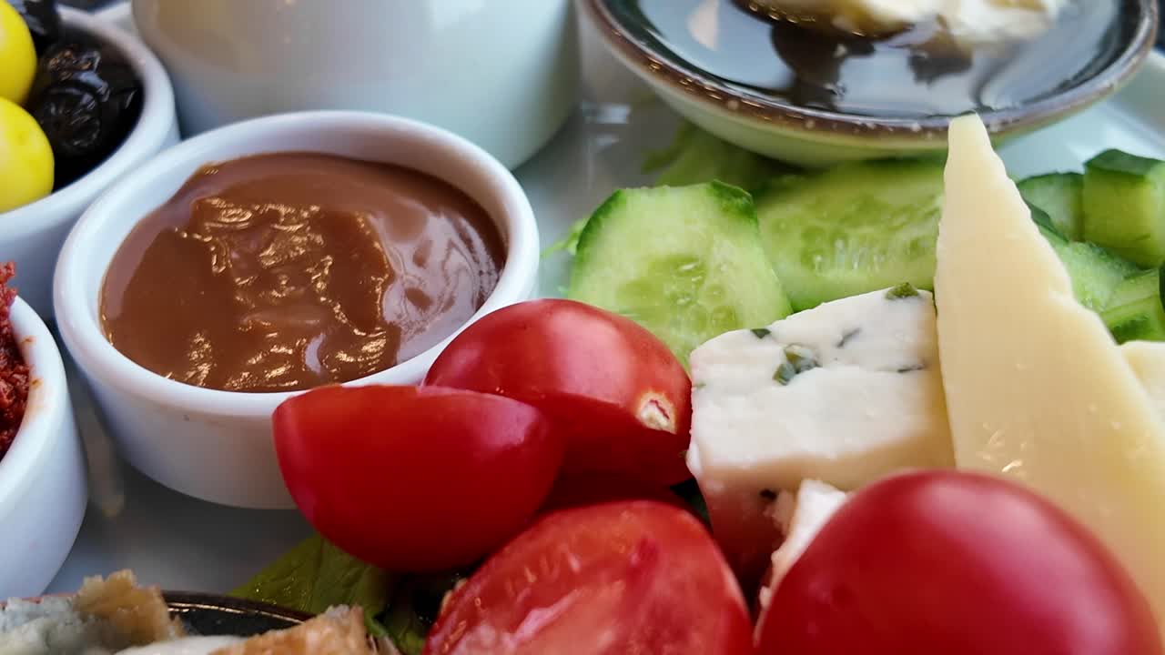 Appetizing Breakfast Plate with Cheese, Tomatoes, Pastry, and Spreads