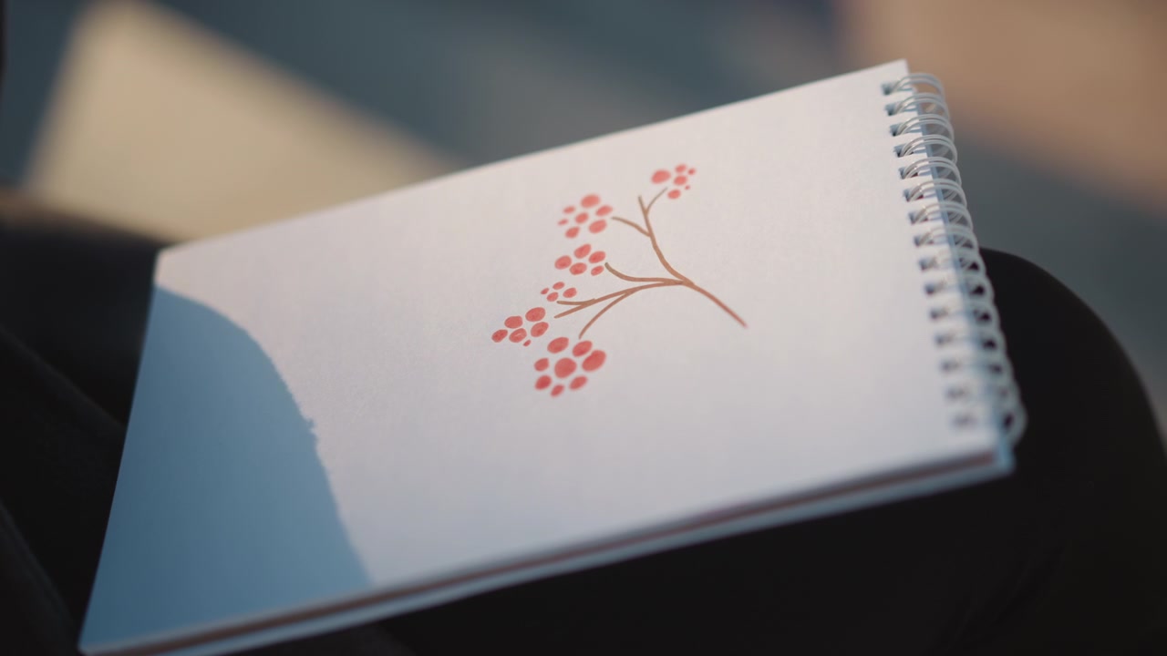 Close-up de um caderno de esboços com uma ilustração de frutas vermelhas.