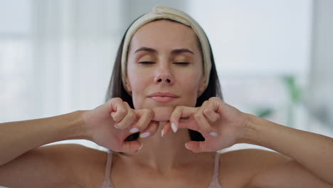 Satisfied-model-massaging-face-indoors-pov-view.-Closeup-woman-skincare-routine