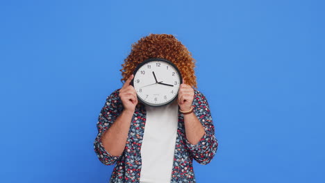 serious strict stylish man holding office clock hiding behind checking time on watch obscuring face