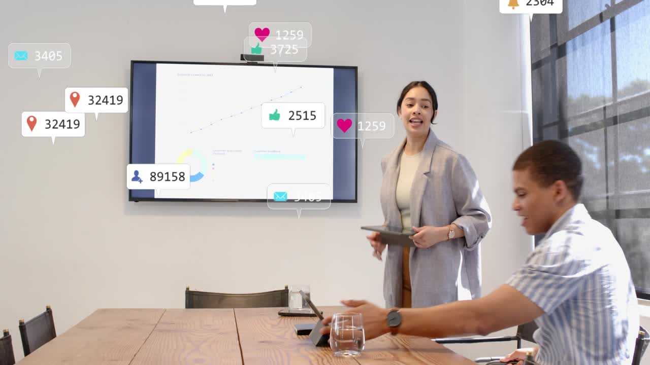 Two colleagues tapping tablets, causing marketing icons to float over chart, host rising to present