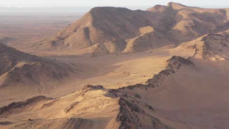 Aerial-forward-over-rocky-and-sandy-mountains-at-Zagora