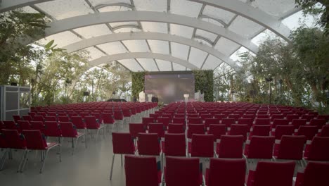 circular shot of spacious empty conference hall decotared with green trees