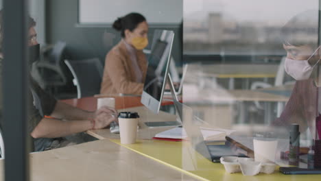 people working in an office with covid-19 safety precautions