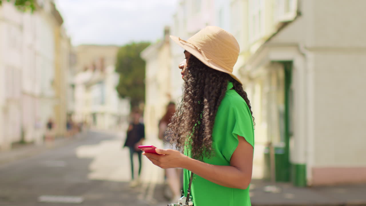 Female Tourist With Camera On Vacation In Oxford UK Exploring City Walking Along Holywell Street Using Mobile Phone For Directions And Information 3