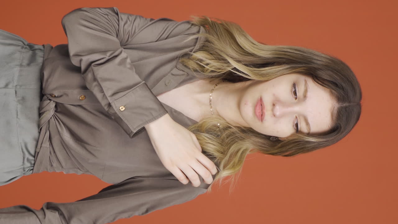 카메라를 바라보는 젊은 여성의 수직 비디오는 가려움증입니다.