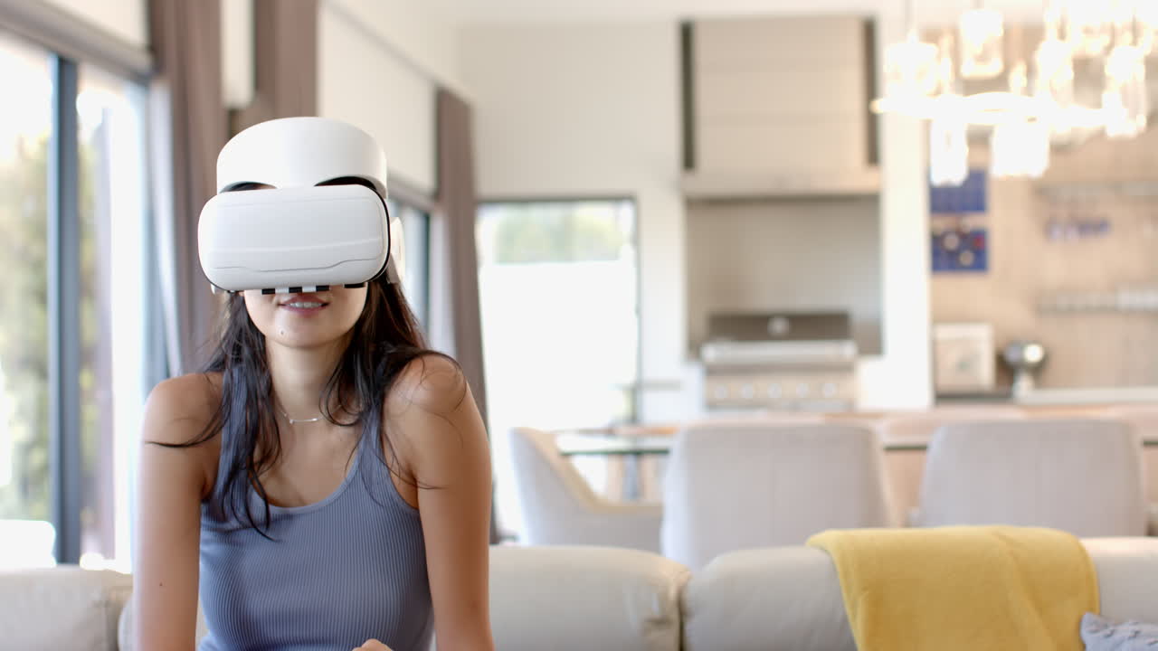 Donna che usa un visore VR, seduta sul divano in un soggiorno moderno, con spazio copia.