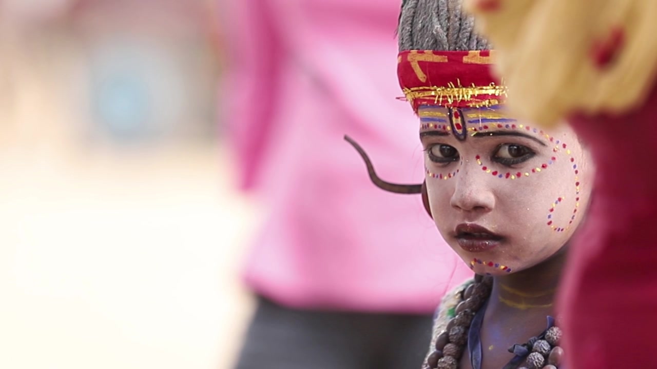Bambino indiano che indossa un costume e trucco del dio Shiva per la fiera a Pushkar. Ripresa ravvicinata al rallentatore. Strade dell'India.