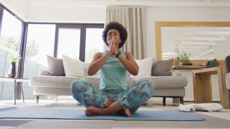 Happy-african-american-wearing-sportswear,-doing-yoga,-meditating