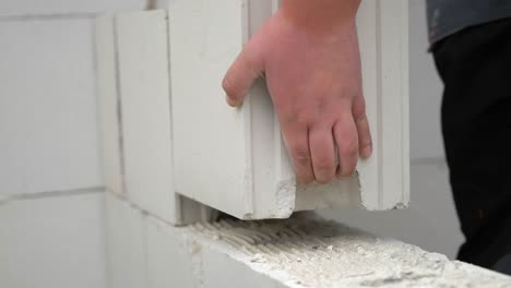 worker's hands laying sand-lime brick