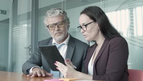 young content assistant showing project data to ceo via tablet