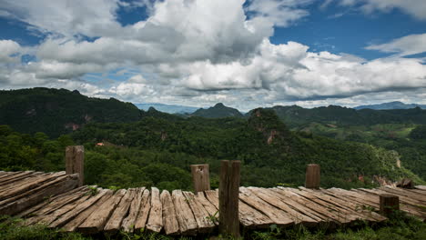 Nubes-Moviéndose-Sobre-Un-Camino-De-Madera-En-Un-Exuberante-Paisaje-Montañoso-Verde,-Timelapse