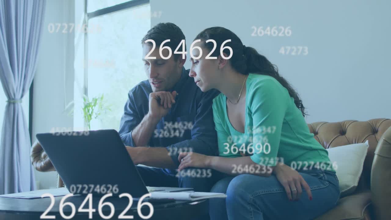 múltiples números cambiantes flotando sobre una pareja caucásica calculando las finanzas juntos en casa