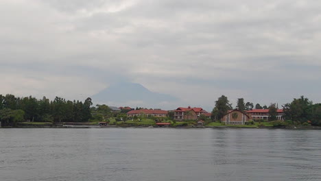 from shore of lake kivu in goma, mt nyiragongo volcano in distance