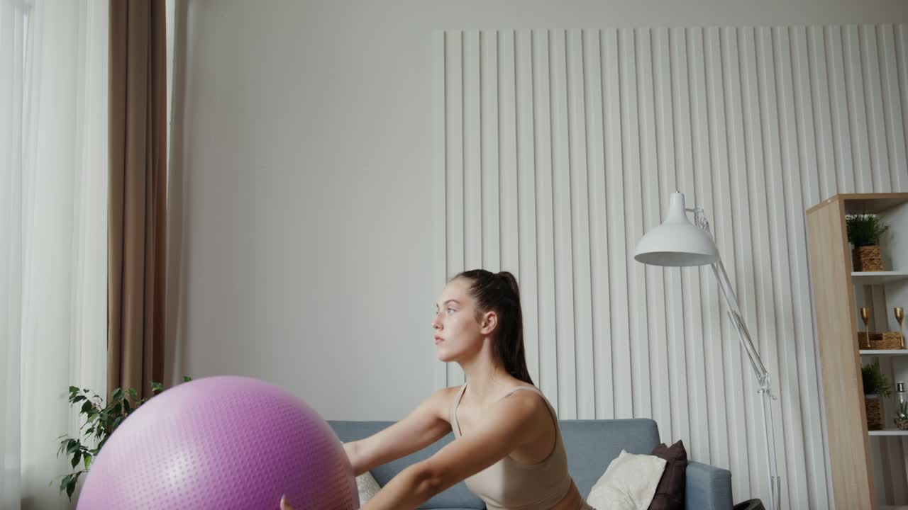 Woman working out at home with an exercise ball