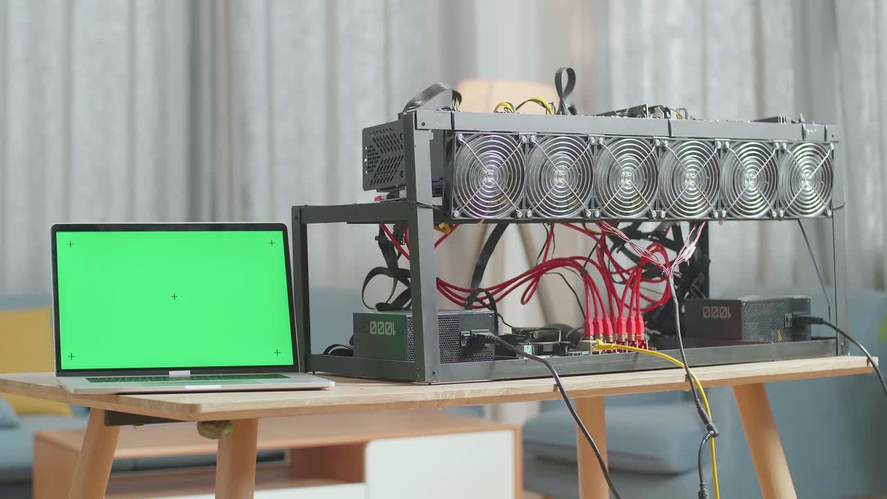 녹색 화면 노트북은 암호화폐 채굴과 함께 테이블에 있습니다.