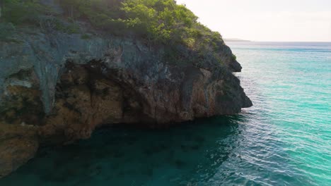 Turquoise-clear-water-and-caves-along-coast-of-Westpunt-Curacao-in-Caribbean-at-sunrise
